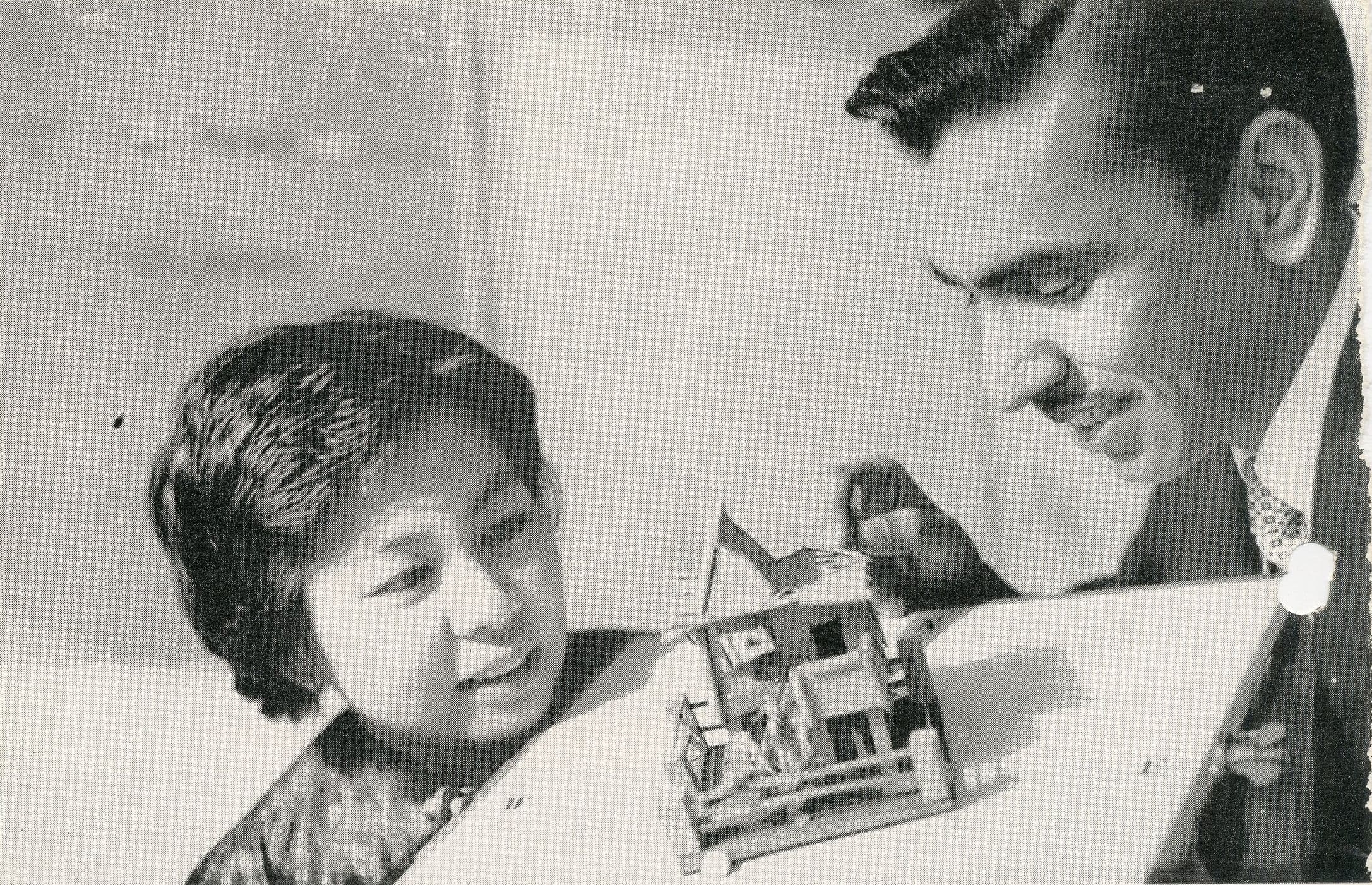 Man and woman examine a small architectural model together.