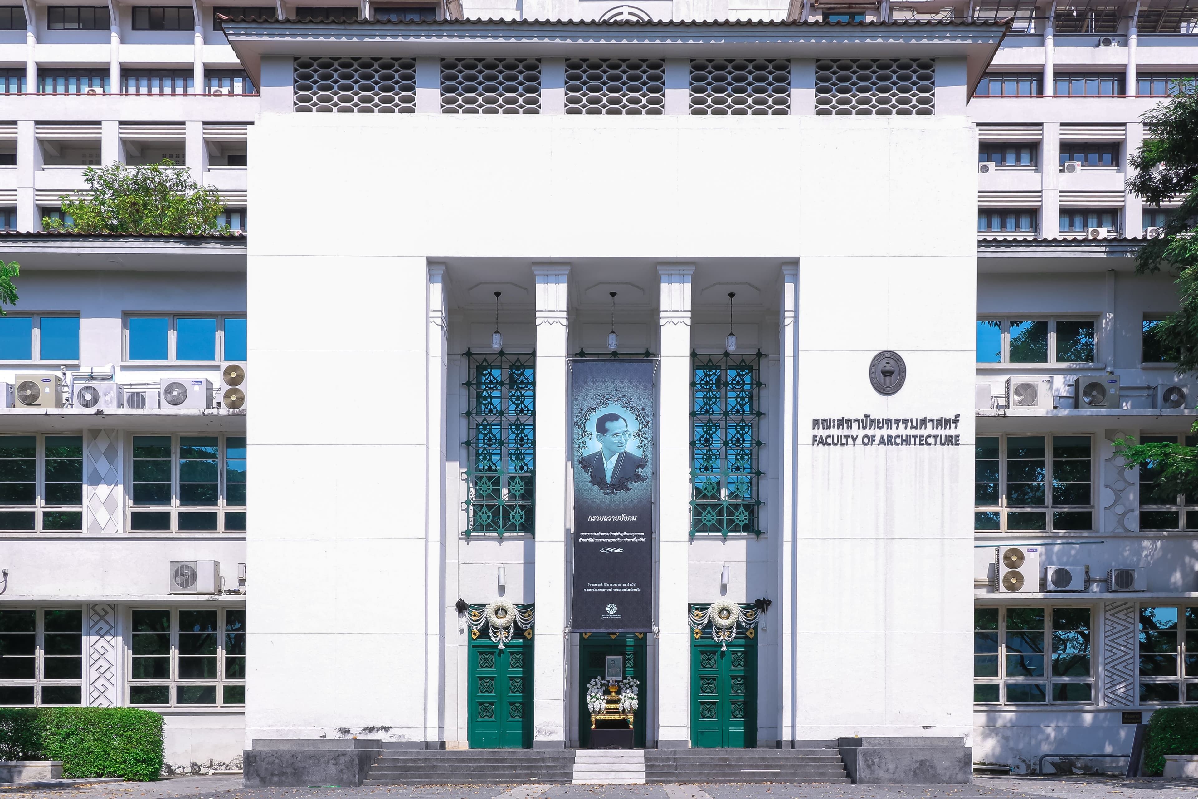 Building facade of the Faculty of Architecture with a portrait and columns.