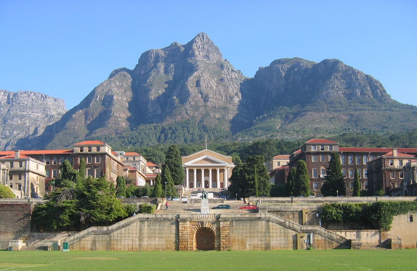 The University of Cape Town's majestic building stands before a towering, rugged mountain peak.