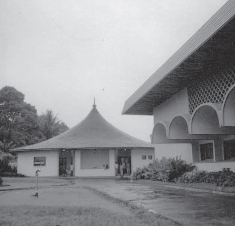Two modern buildings with distinctive architectural styles, one with a conical roof and another with arched windows.
