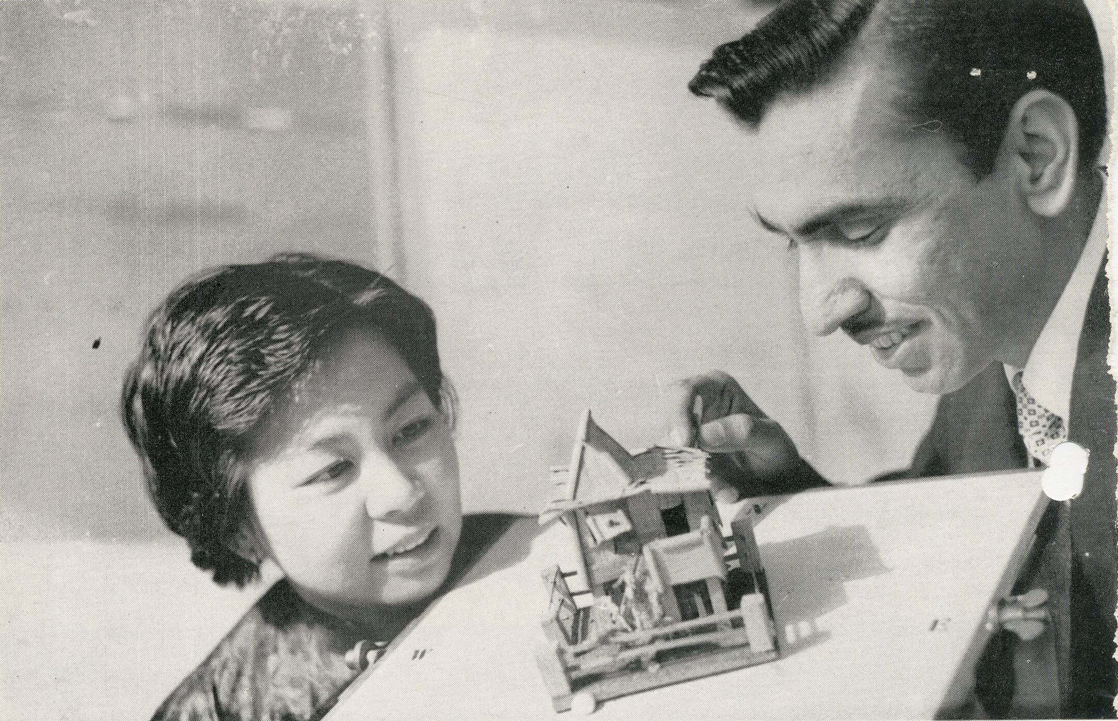Man and woman examine a small architectural model together.
