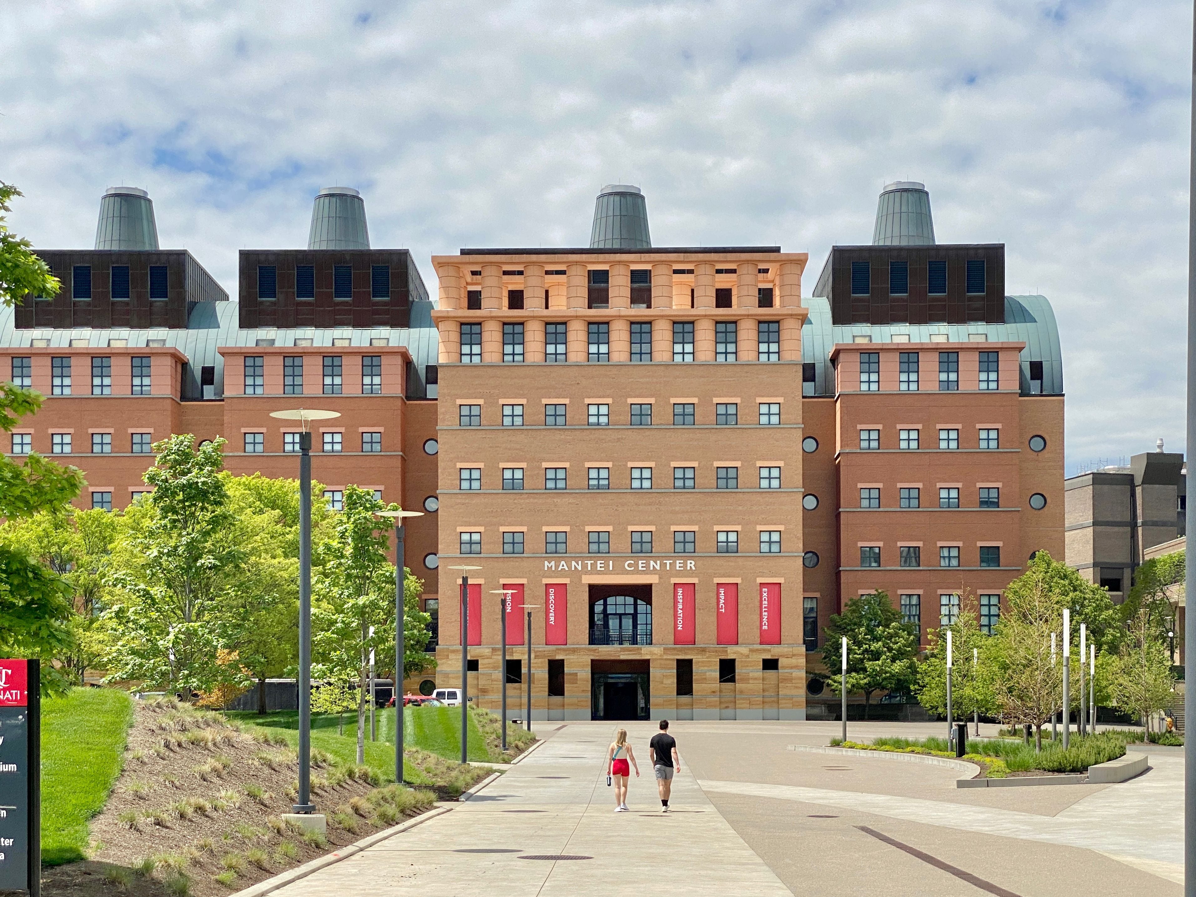 University building with red banners and four distinct rooftop structures.