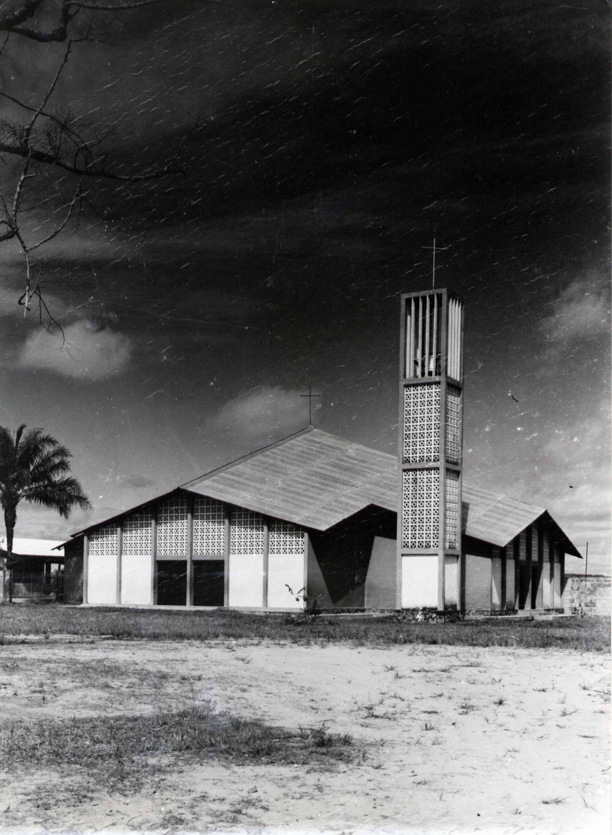 Modernist church building with a tall, square bell tower and a sloping roof.