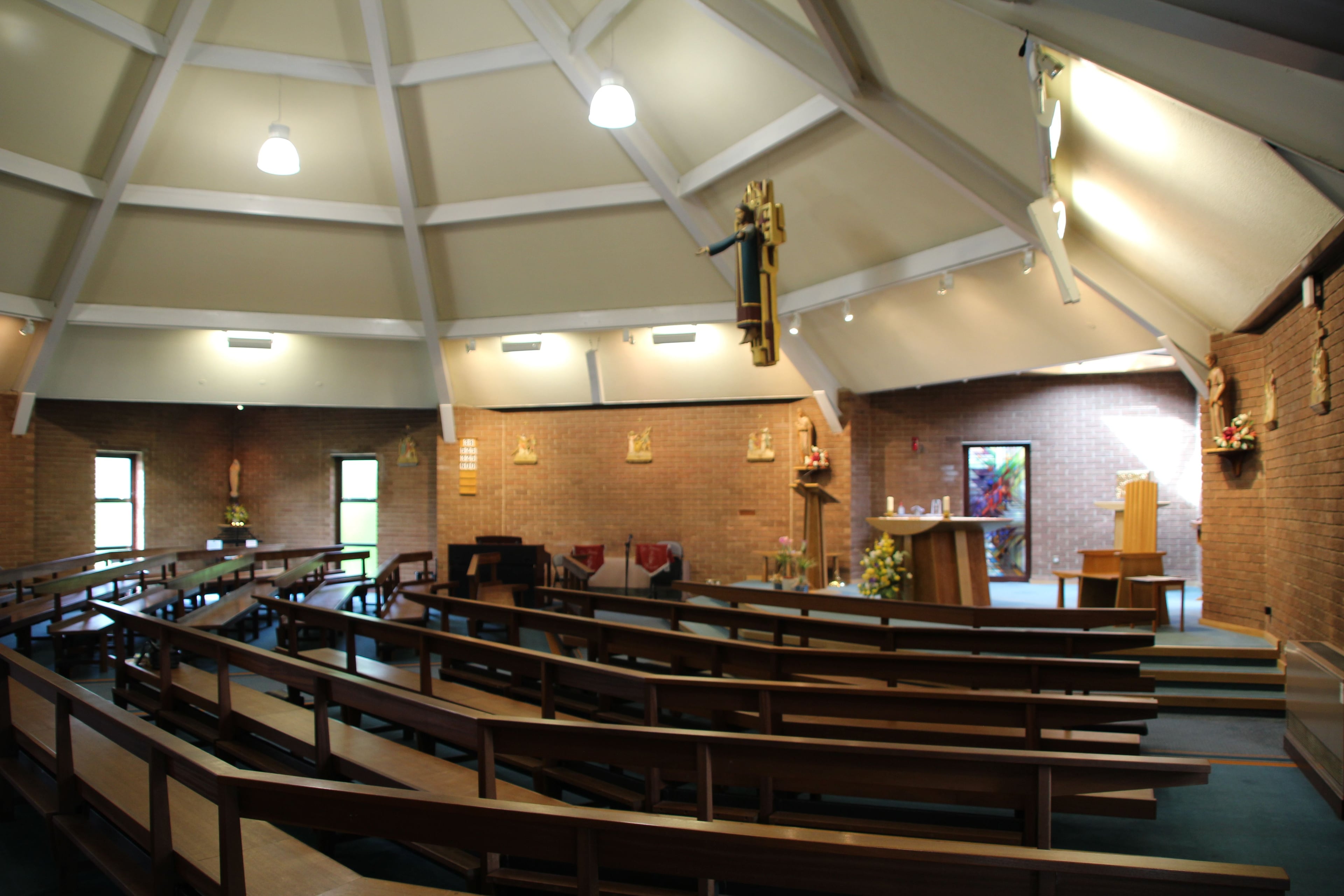 Interior of a church with wooden pews arranged in a circular fashion around an altar.