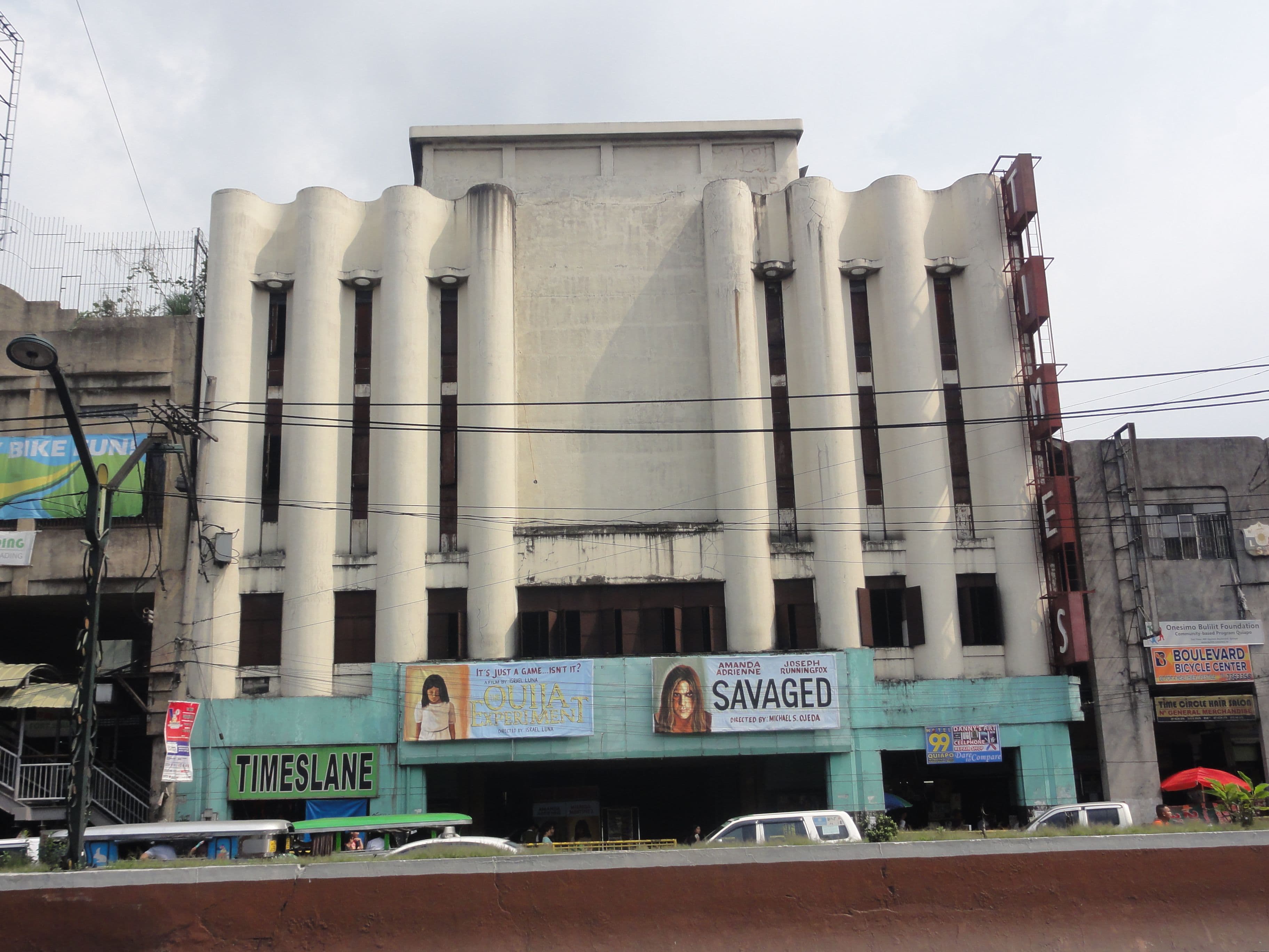 Art Deco movie theater with vertical grooved pillars and a marquee displaying