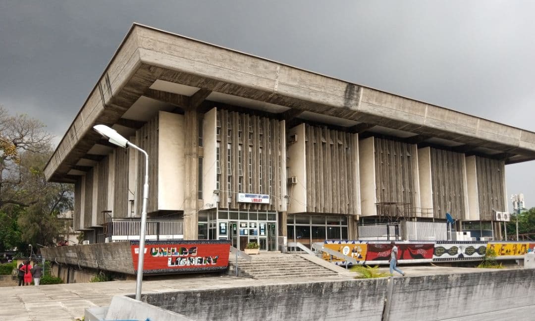 Brutalist concrete building with vertical fins under an overcast sky.
